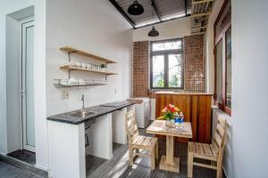 顺化Lam Vien Homestay Hue的带水槽和桌椅的厨房