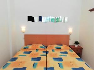 a bedroom with a bed with a yellow and blue comforter at Trill Mirasol E estudio 1a linea mar in L'Estartit +13 photos