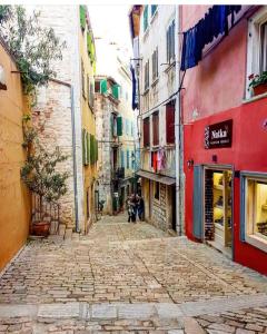 an alley in a city with people walking down it at Grisia 26 Apartment in Rovinj