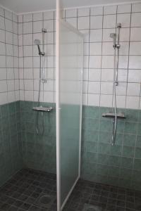 a bathroom with a shower with green and white tiles at Labbnäs Semesterhem in Kimitoön +38 photos