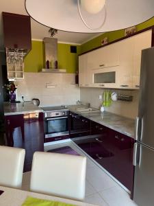 una cocina con electrodomésticos en blanco y negro y paredes verdes en Silver Mazury Apartament en Giżycko