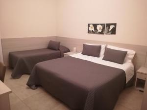 una habitación de hotel con 2 camas y una silla en Casa Vacanze Bella Giulia en Ragusa
