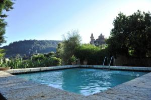 a swimming pool with a house in the background at Hotel Sa Vall in Valldemossa