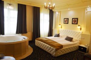 Hotel Venecia Palace في ميخاووفيتسه: غرفة نوم بسرير كبير وحوض استحمام