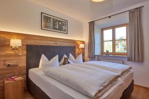 a bedroom with a large bed with white pillows at Chalet Menkenhof in Reit im Winkl