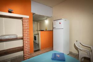 a small kitchen with a white refrigerator in a room at Pousada Pantanal in Ladário