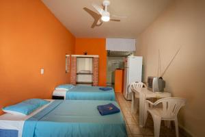 a bedroom with two beds and a ceiling fan at Pousada Pantanal in Ladário