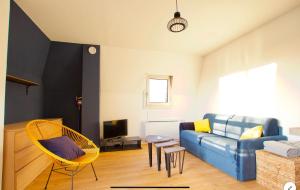 a living room with a blue couch and yellow chairs at Joli studio ☆ 100m de la mer et du centre ville ☆ in Cabourg