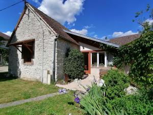 a small white brick house with flowers in the yard at Forest Farm in Bois-Jérôme-Saint-Ouen