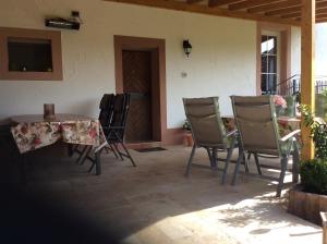 eine Terrasse mit einem Tisch und Stühlen sowie einem TV in der Unterkunft Pension Schmitz in Serrig