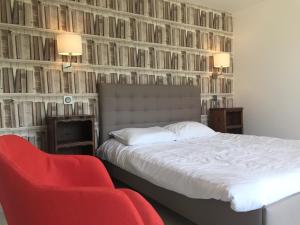 een slaapkamer met een bed en een rode stoel bij Maison/gîte-6 km de Tours in La Membrolle-sur-Choisille