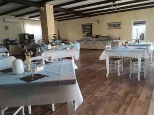 a dining room with white tables and chairs at Alghero Vacanze Hotel in Alghero