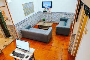 ein Wohnzimmer mit einem Sofa und einem Laptop auf dem Tisch in der Unterkunft Help Yourself Hostels - Restelo in Lissabon