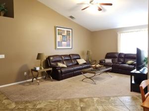 sala de estar con muebles de cuero y ventilador de techo en Quiet Neighborhood off La Canada, en Tucson