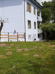 une maison blanche avec une clôture et une pelouse dans l'établissement GrappaLand, à Crespano del Grappa