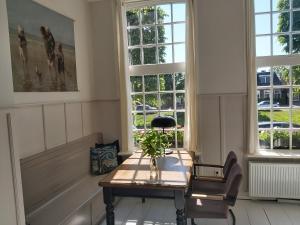 a room with a table and two windows at De Wachtkaemer in De olde banck in Stavoren