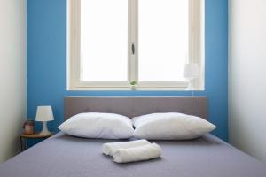 a bed with two white pillows and a window at Maisonnette avec jardin, parc du chêne (tram T5) in Bron