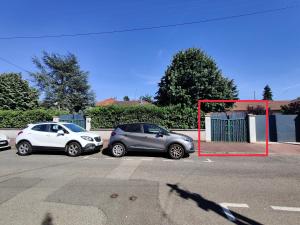 kilka samochodów zaparkowanych na parkingu w obiekcie Maisonnette avec jardin, parc du chêne (tram T5) w mieście Bron