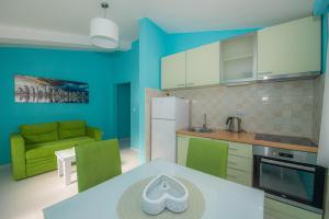 Apartments Biskupović في Muo: مطبخ بجدران زرقاء وطاولة وأريكة
