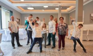 eine Gruppe von Menschen, die in einem Raum mit den Händen in der Luft stehen in der Unterkunft Hotel Weinberg-Schlößchen in Oberheimbach