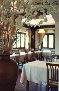 une salle à manger avec une table, des chaises et un vase dans l'établissement L'Oliveto, à Cineto Romano