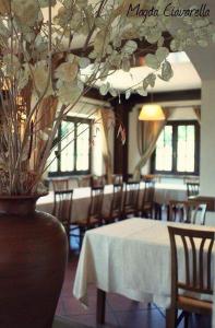 a dining room with a table and chairs and a vase at L'Oliveto in Cineto Romano