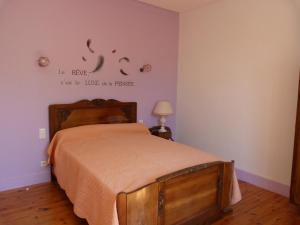 een slaapkamer met een bed en een bord aan de muur bij chez Patricia in Cransac