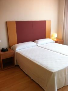 a hotel room with a bed and a lamp at Hotel-Apartamentos Tartesos in Las Rozas de Madrid