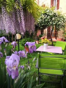 una mesa y sillas en un jardín con flores púrpuras en Al Giardino Di Alice, en Perugia
