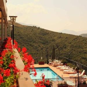 una piscina con sedie e una montagna sullo sfondo di L'Oliveto a Cineto Romano