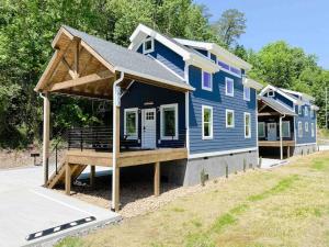 una casa azul con un porche en el lateral de ella en Cozy Smoky Mountain Tiny House, en Pigeon Forge