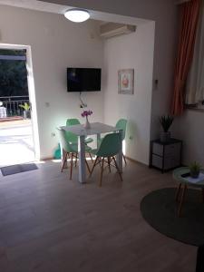 - un salon avec une table et des chaises blanches dans l'établissement Apartments Viki, à Trogir