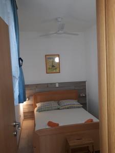 - un lit avec un cadre en bois dans une chambre dans l'établissement Apartments Viki, à Trogir