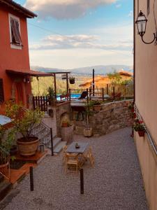 eine Terrasse eines Hauses mit einem Tisch und einem Tisch in der Unterkunft Casa Emma Fiattone in Garfagnana in Fiattone