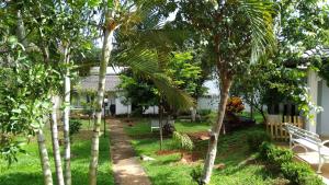 un jardín con palmeras y un banco blanco en Alt House Qi 02 Lago Norte, en Brasilia