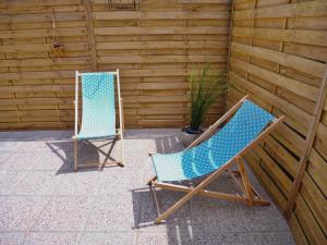 two chairs sitting next to each other on a patio at La cabane du chasseur in Flines-lès-Mortagne