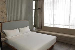 a bedroom with a large white bed and a window at Ana Hotel Jakarta in Jakarta