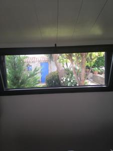una ventana en una habitación con un árbol en Le Buzet Bleu Bed & Breakfast en Noirmoutier-en-l'lle