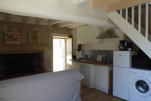 a kitchen with a washer and dryer in a room at Maisonnette climatisée avec parking privé in Montfort