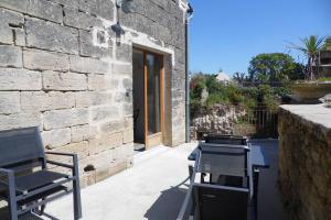 a patio with two chairs and a grill and a building at Maisonnette climatisée avec parking privé in Montfort