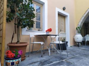 a patio with a table and chairs and a potted plant at Kalymnos Studio just4two in Kalymnos