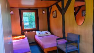 ein kleines Zimmer mit 2 Betten und einem Fenster in der Unterkunft Domek pod lasem in Mikołajki
