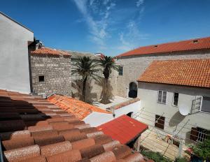an overhead view of roofs of buildings with palm trees at Old town house in Pag