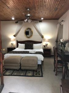 een slaapkamer met een bed, een tafel en een spiegel bij Brooklyn Guesthouses in Pretoria