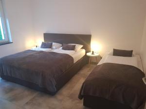 two beds in a bedroom with two lamps on at Apartamenty KADO in Karpacz