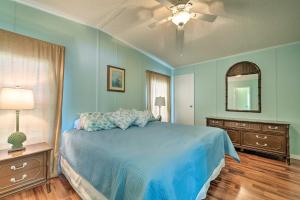 a bedroom with a blue bed and a ceiling fan at Anglers Getaway Homosassa Home with Boat Dock! in Homosassa