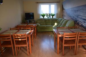 a living room with a couch and tables and chairs at Pokoje Gościnne Alpinka in Ustka