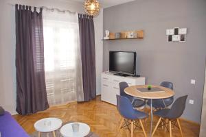 a living room with a table and a tv at Apartments Mike in Novalja