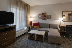 a living room with a couch and a flat screen tv at Staybridge Suites - Phoenix – Biltmore Area, an IHG Hotel in Phoenix