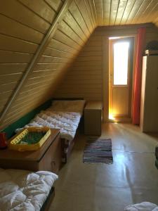 a attic room with two beds and a door at Chata Strmá in Jeseník